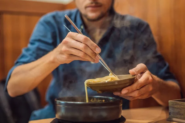 Homem turista comer macarrão coreano em um café coreano. Conceito de viagem Coreia — Fotografia de Stock