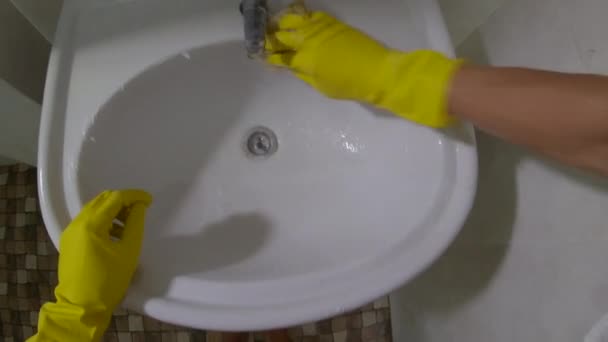 Synvinkel skott - man i en gul sanitetshandskar tvättar diskbänken — Stockvideo
