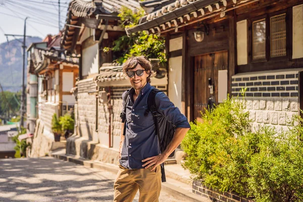 Młody człowiek turysta w Bukchon Hanok Village jest jednym z najbardziej znanych miejsc koreańskich tradycyjnych domów zostały zachowane. Podróż do Korei Concept — Zdjęcie stockowe