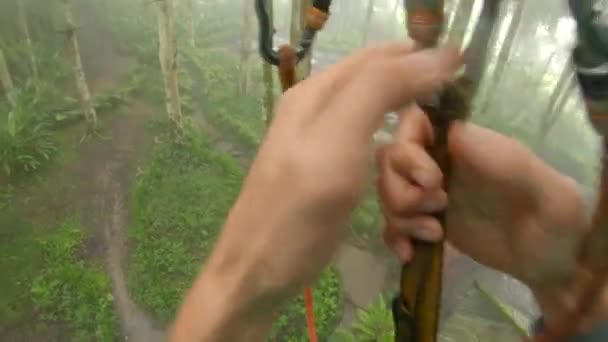 Point de vue d'un homme dans un harnais de sécurité qui grimpe sur un chemin en cime des arbres dans un parc d'aventure forestière. Il grimpe sur le sentier des hautes cordes. Centre de loisirs extérieur avec activités d'escalade 