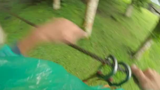 Point de vue d'un homme dans un harnais de sécurité qui grimpe sur un chemin en cime des arbres dans un parc d'aventure forestière. Il grimpe sur le sentier des hautes cordes. Centre de loisirs extérieur avec activités d'escalade 