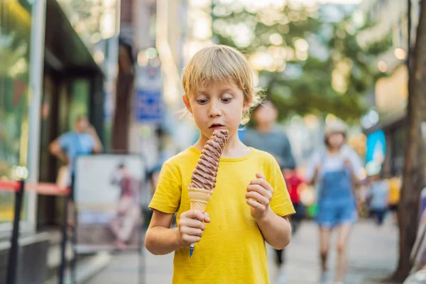 Little tourist boy eating 32 cm ice cream. 1 foot long ice cream. Long ice cream is a popular tourist attraction in Korea. Travel to Korea concept. Traveling with children concept — Stock Photo, Image