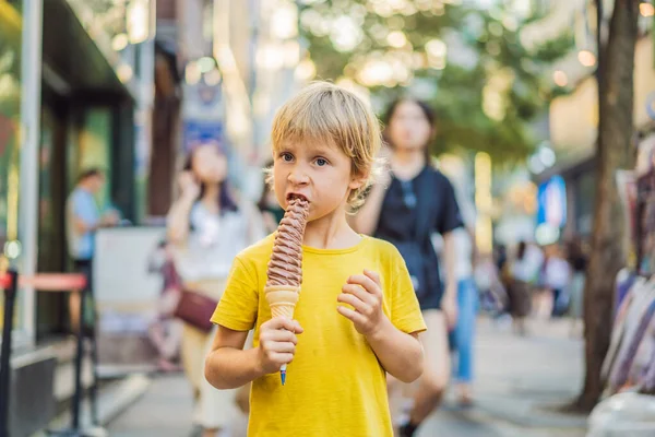 Little tourist boy eating 32 cm ice cream. 1 foot long ice cream. Long ice cream is a popular tourist attraction in Korea. Travel to Korea concept. Traveling with children concept — Stock Photo, Image