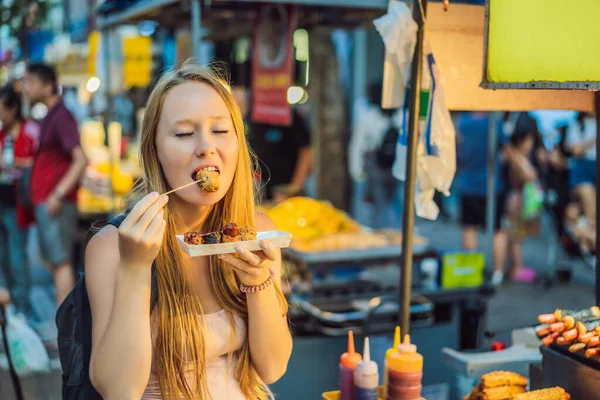 Młoda turystka jedząca typowe koreańskie jedzenie na ulicy Seulu. Pikantne fast food po prostu znaleźć na lokalnym koreańskim rynku, Soul Korea — Zdjęcie stockowe