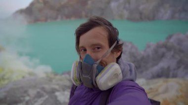 Genç bir gezgin, Ijen volkanı ya da Kawah Ijen 'in içinde büyük bir asit gölü olan kraterinde selfie videosu çeker. Java Adası, Endonezya