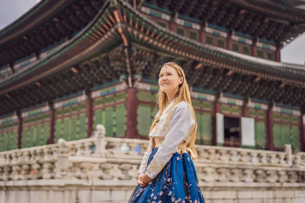 Giovane turista donna caucasica in hanbok abito coreano nazionale a palazzo coreano. Viaggio in Corea concetto. Abbigliamento nazionale coreano. Intrattenimento per i turisti - provare abbigliamento nazionale coreano — Foto Stock