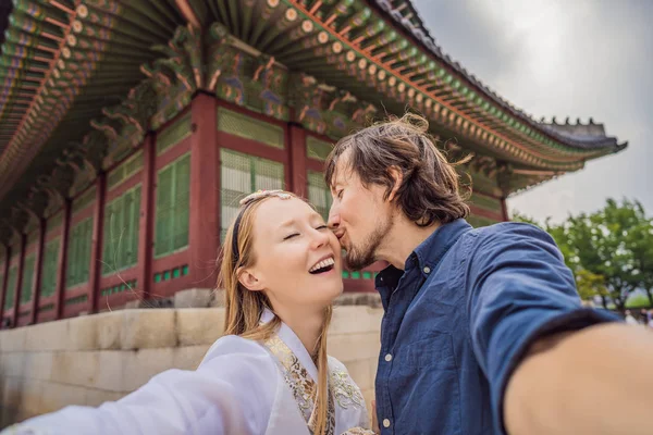 Pareja joven de cónyuges o novia y novio o esposo y esposa o novio y novia pasan tiempo en Corea. Mujer en hanbok vestido nacional coreano.Vacaciones en Corea. Luna de miel, viaje a Corea — Foto de Stock