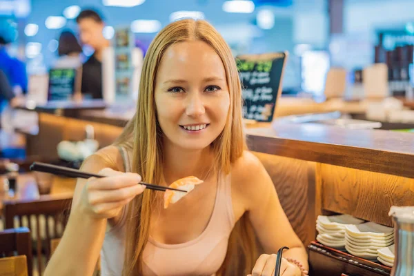 Young woman eating sushi in a cafe — Stock Photo, Image
