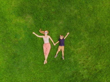 Anne ve oğlu parkta, çimlerin üzerine fotoğraflardan dron, quadracopter yalan söylüyorsun