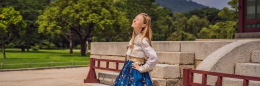 Hanbok Ulusal Kore elbisesi içinde genç beyaz kadın turist. Kore konseptine seyahat. Ulusal Kore giysileri. Turistler için eğlence - ulusal Kore giyim bayrağı deneniyor, Long Format