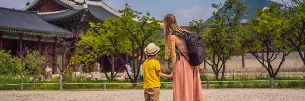 어머니와아 들 이 한국 서울을 찾는 관광객. 한국으로 의 여행. 아이들 과 함께 긴 형식의 배너를 가지고 여행하는 모습 — 스톡 사진