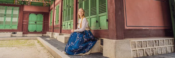 Ung kaukasisk kvinnlig turist i hanbok nationell koreansk klänning Res till Korea koncept. Nationella koreanska kläder. Underhållning för turister - provar på nationella koreanska kläder Banner, Long Format — Stockfoto