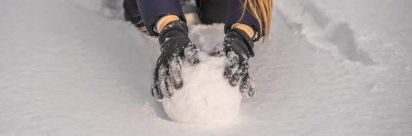 Mujer joven rodando bola de nieve gigante para hacer muñeco de nieve BANNER, FORMATO LARGO — Foto de Stock