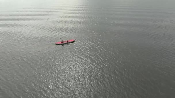 一个年轻人和他的儿子在海上或湖中的充气皮划艇上划桨 — 图库视频影像