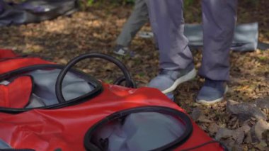 Gölde ya da deniz kenarında genç bir adam yüzmek için şişme bir kano hazırlar.