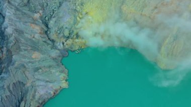 Hava görüntüsü. Java adasındaki ünlü aktif bir Ijen yanardağında ya da Kawah Ijen 'de gün doğumu. Krateri, dünyadaki en büyük asit gölüyle doludur. Ve volkanik gazların gittiği bir sülfür madeni var.