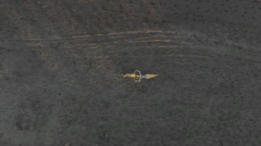 Anne ve oğlunun siyah bir kumsalda uzanırken çekilmiş bir fotoğrafı.