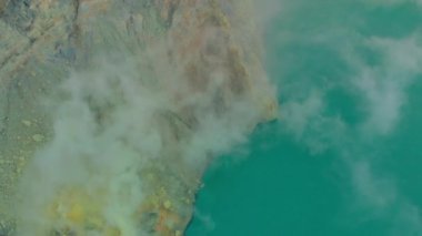 Hava görüntüsü. Java adasındaki ünlü aktif bir Ijen yanardağında ya da Kawah Ijen 'de gün doğumu. Krateri, dünyadaki en büyük asit gölüyle doludur. Ve volkanik gazların gittiği bir sülfür madeni var.