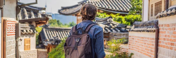 Junge Mann Tourist in bukchon hanok Dorf ist einer der berühmten Ort für koreanische traditionelle Häuser erhalten geblieben sind. Reise nach Korea Konzeptbanner, Langformat — Stockfoto