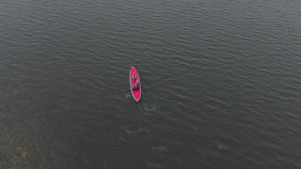 Un joven y su hijo reman en el kayak inflable en un mar o en un lago — Vídeo de stock