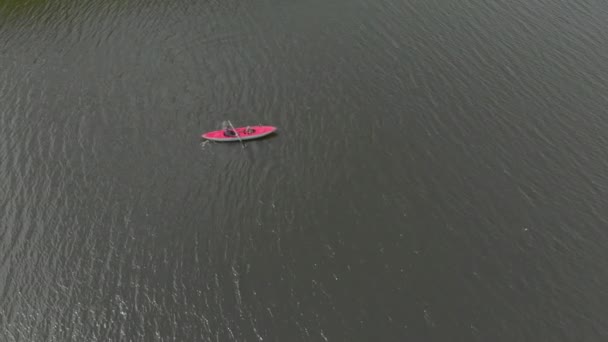 Een jongeman en zijn zoon peddelen in de opblaasbare kajak in een zee of in een meer — Stockvideo