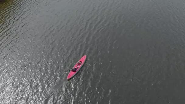 A young man and his son paddle in the inflatable kayak in a sea or in a lake — Stock Video