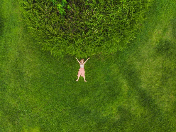 Jovem deitada no meio de um campo e relaxante, drone foto — Fotografia de Stock