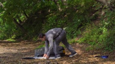 Gölde ya da deniz kenarında genç bir adam yüzmek için şişme bir kano hazırlar.