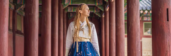 Jonge Kaukasische vrouwelijke toerist in hanbok nationale koreaanse jurk Reizen naar Korea concept. Nationale Koreaanse kleding. Entertainment voor toeristen - Nationale Koreaanse kleding passen Banner, Long Format — Stockfoto