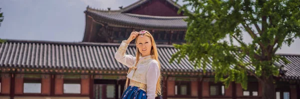 Jovem turista caucasiana em hanbok vestido coreano nacional. Viajar para a Coreia conceito. Roupas nacionais coreanas. Entretenimento para turistas - experimentando roupas nacionais coreanas BANNER, LONG FORMAT — Fotografia de Stock