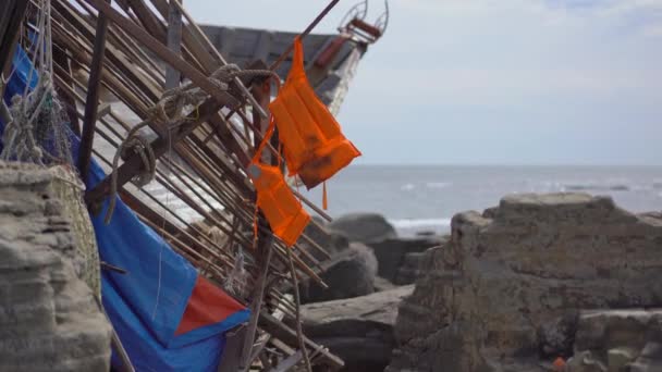 돌 바다에 떠 있는 어선의 잔해에 매달려 있는 구명조끼를 입고 있었다. 난파선 개념이야. 난파선에서 살아남은 사람은 아무도 없었습니다 — 비디오