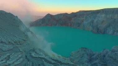 Hava görüntüsü. Java adasındaki ünlü aktif bir Ijen yanardağında ya da Kawah Ijen 'de gün doğumu. Krateri, dünyadaki en büyük asit gölüyle doludur. Ve volkanik gazların gittiği bir sülfür madeni var.