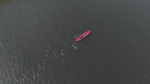 海や湖の中の膨脹可能なカヤックに若い男と彼の息子のパドル — ストック動画