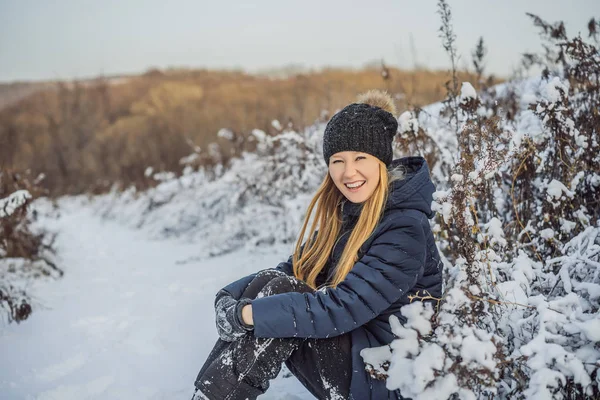 První sníh se těší: mladá žena venku na krásné lesní cestě sledovat sněhové vločky padající — Stock fotografie
