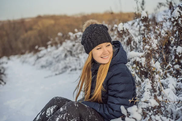 Наслаждаясь первым снегом: молодая женщина на открытом воздухе на прекрасной лесной дорожке, наблюдая за падающими снежинками — стоковое фото