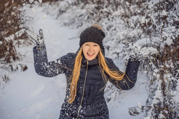 Žena se baví v zimě, hází sníh — Stock fotografie