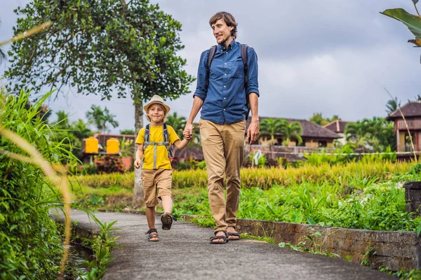 Pai e filho turistas em Bali caminha ao longo das ruas aconchegantes estreitas de Ubud. Bali é um destino turístico popular. Viaje ao conceito de Bali. Viajar com conceito de crianças — Fotografia de Stock