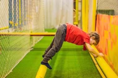 Kask takıp tırmanan 6 yaşındaki bir çocuğun portresi. Macera çocuk parkında abstacle kursu