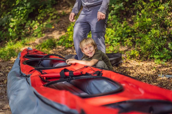 Father and son prepare a kayak for rowing on the sea — Stock Photo, Image