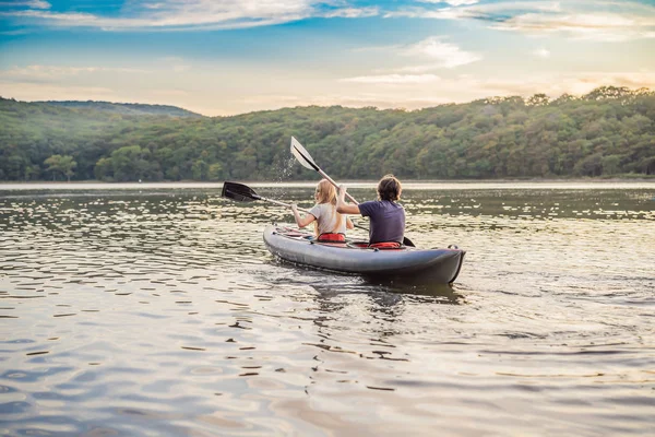 Man och kvinna simmar på kajak i havet på bakgrunden av ön. Kajakpaddlingskoncept.Kajakpaddlingskoncept med faderns familj till sjöss — Stockfoto