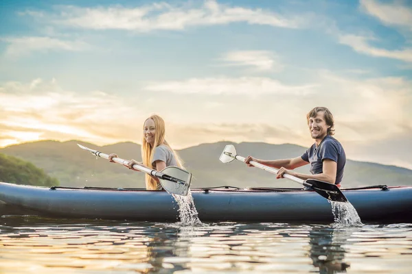 L'uomo e la donna nuotano sul kayak in mare sullo sfondo dell'isola. Concetto di kayaking.Concetto di kayak con famiglia di madre di padre in mare — Foto Stock