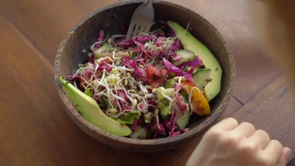 Mladá žena v kavárně jí zdravý vegetariánský salát. Veganský koncept jídla — Stock video