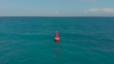 Güzel mavi bir denizde kırmızı bir şamandıranın havadan görüntüsü.