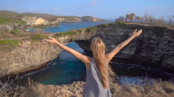 Fiatal nő turista látogasson el a Broken Beach, híres turisztikai hely a Nusa Penida sziget, Indonézia. Utazás Indonéziába — Stock videók