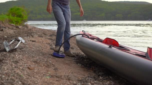 El joven infla su kayak y lo prepara para remar en un lago o mar. Disparo en cámara lenta — Vídeos de Stock