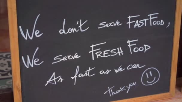 Escribiendo en una pizarra "No servimos comida rápida, servimos comida fresca " — Vídeo de stock