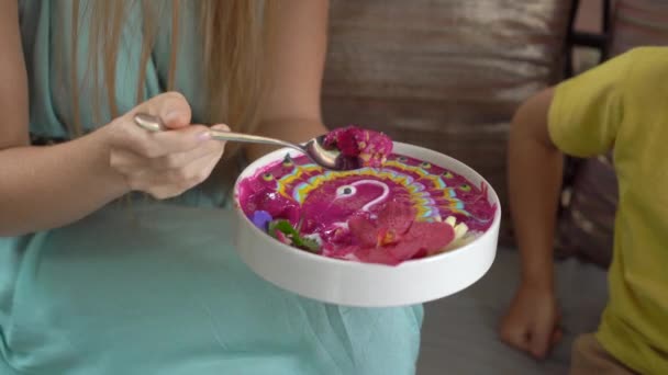 Genç bir kadın ve küçük oğlu güzel bir kafede oturmuş renkli granola kokteylinin tadını çıkarıyorlar. Sağlıklı yeme kavramı — Stok video