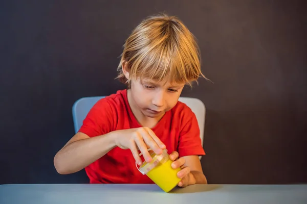 Niño jugando juguete hecho a mano llamado limo. Un niño juega con limo. Chico exprimir y estirar limo —  Fotos de Stock