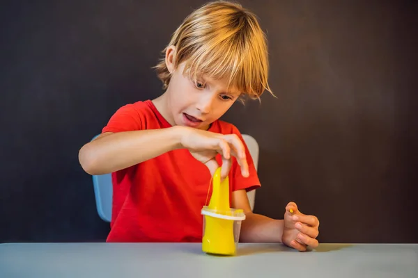 Băiatul jucându-se de mână a făcut jucărie numită slime. Copilul se joacă cu slime. Kid stoarce și stretching slime — Fotografie, imagine de stoc