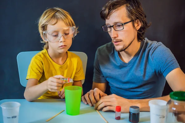 Отец и сын проводят химические эксперименты дома. Домашняя слизь — стоковое фото